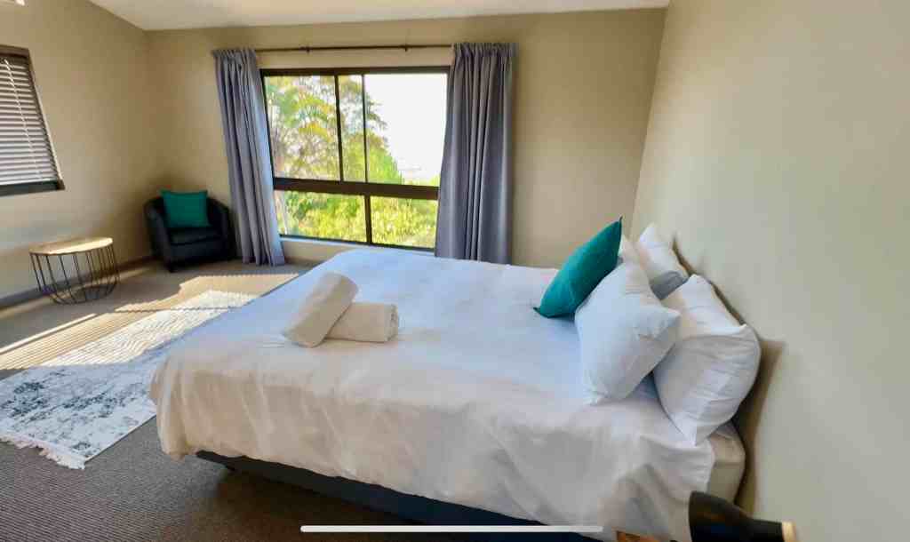 Modern bedroom with large window and scenic view for a peaceful stay.